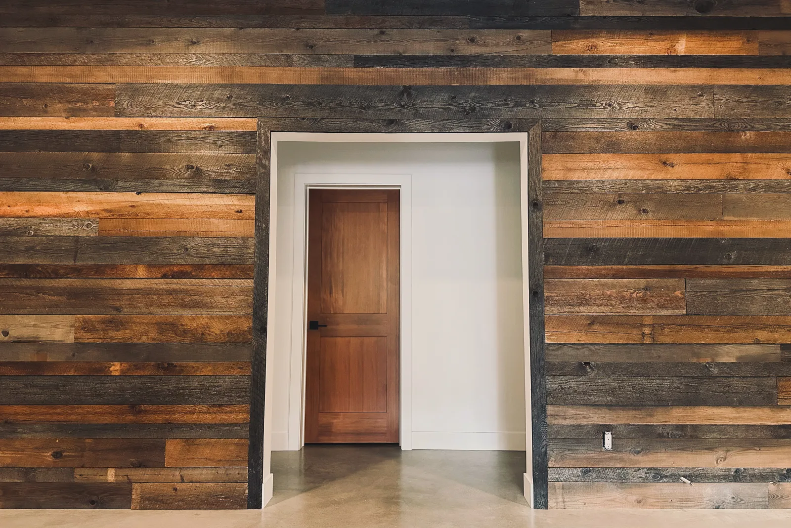 Reclaimed barnboard feature wall framing a solid interior door