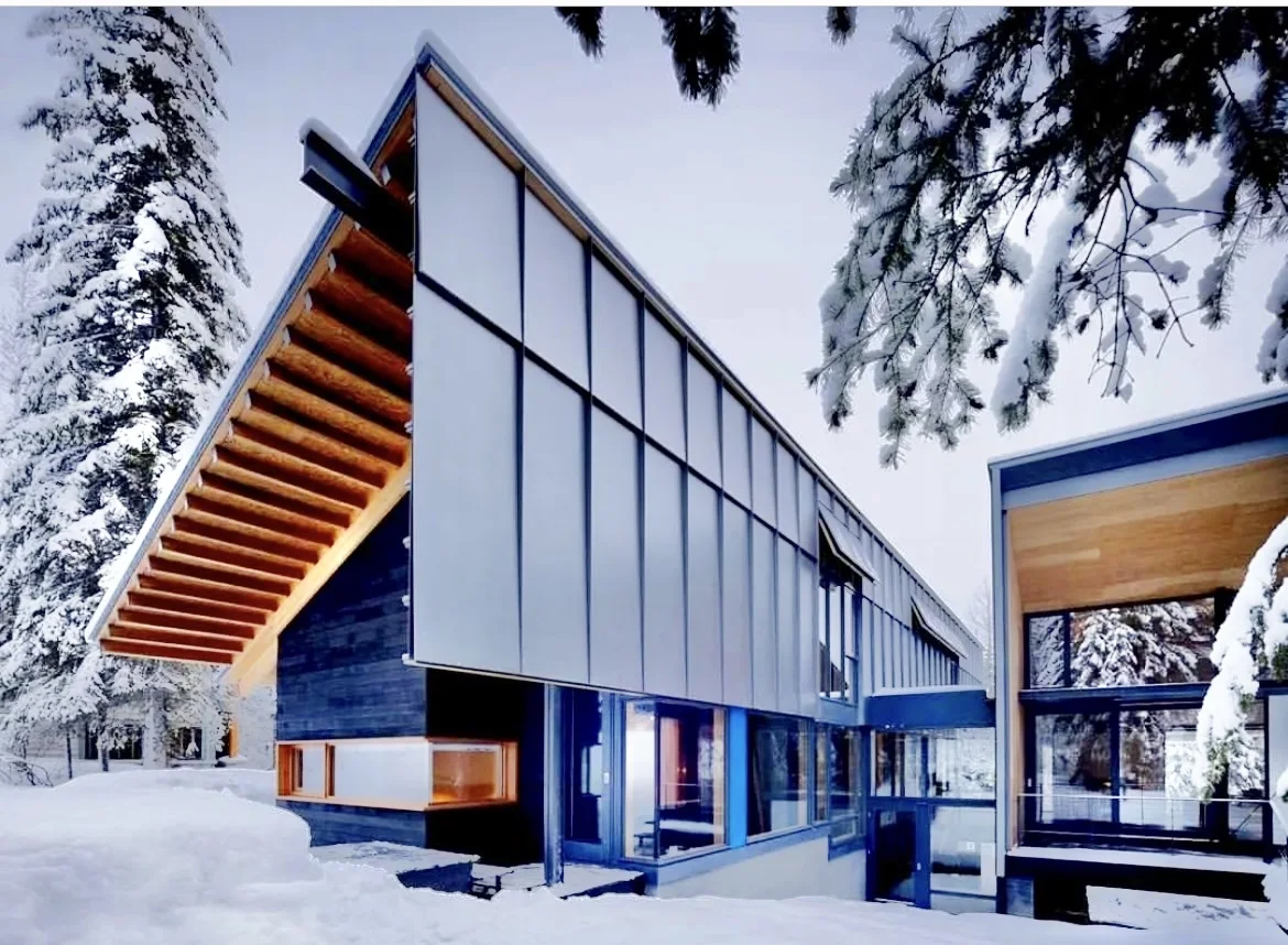 Modern lakeside build in winter, glazed elevation under a deep overhang