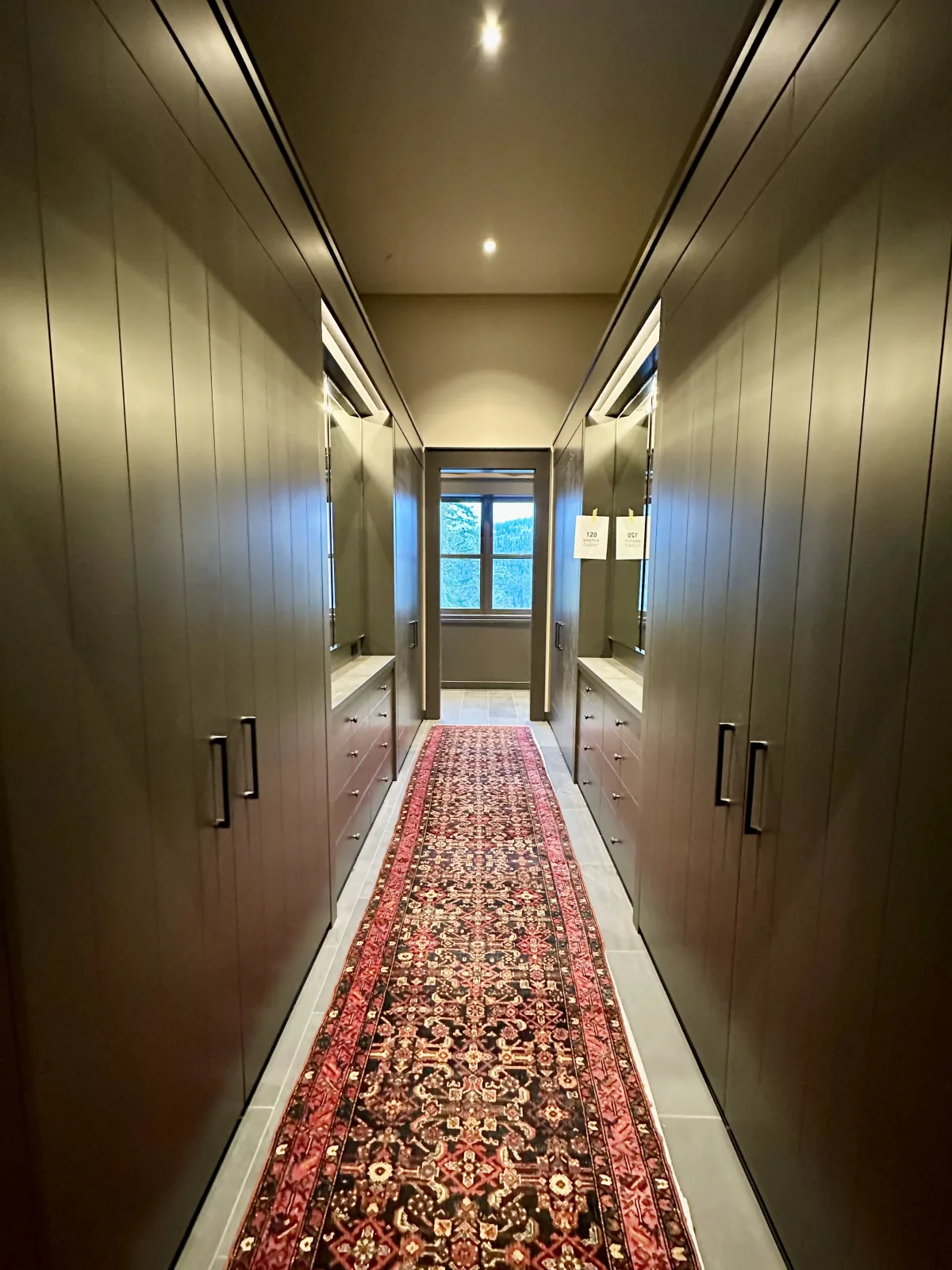 Dressing corridor lined both sides with dark full height cabinetry