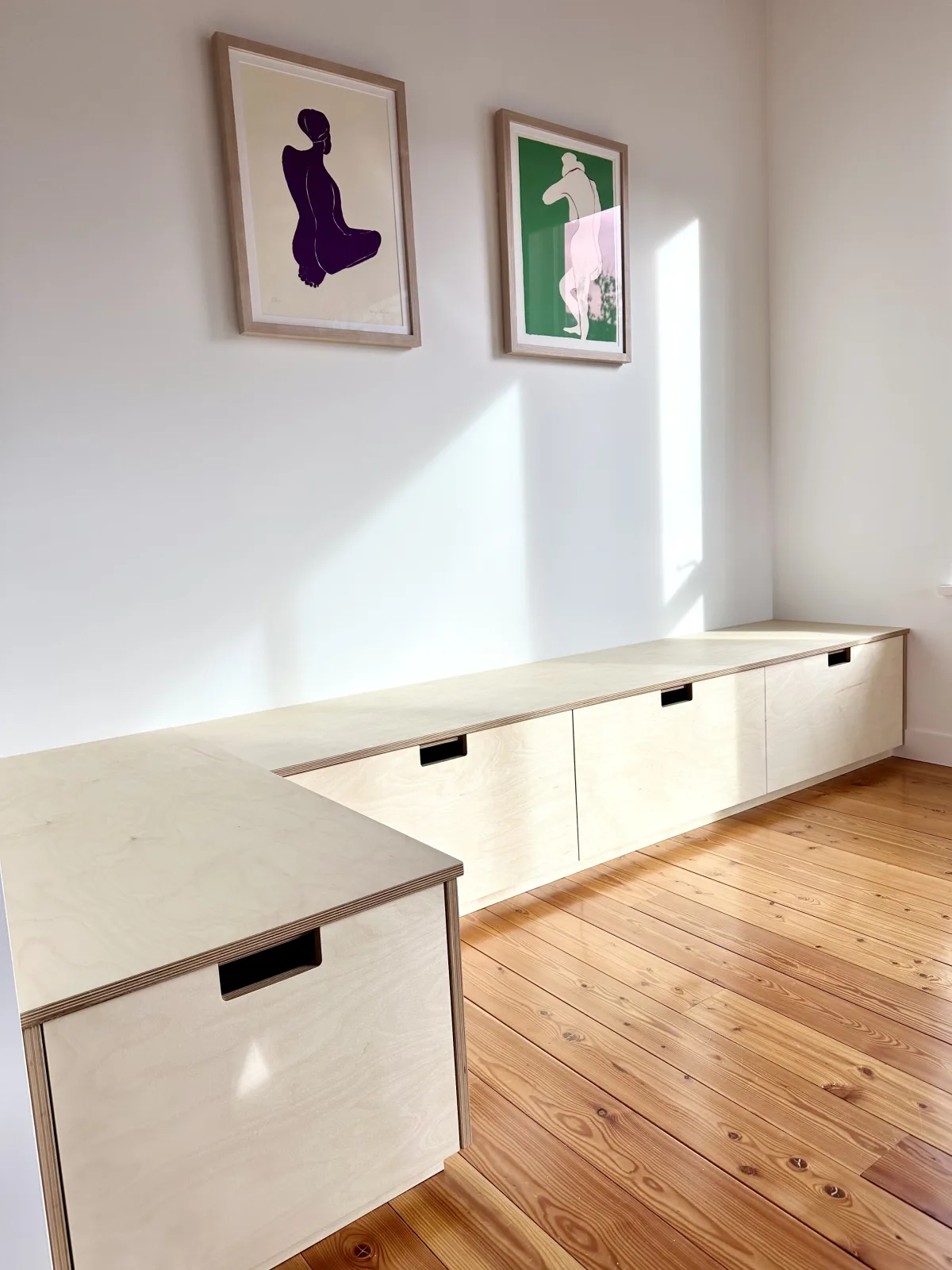 Built in birch bench and drawer run wrapping a corner over a pine floor
