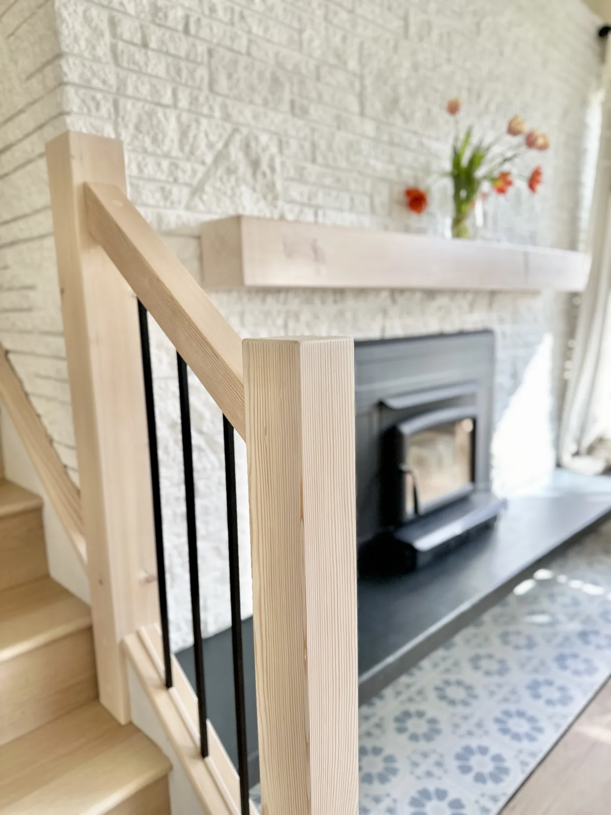 Timber stair post and a solid mantel against a painted brick fireplace